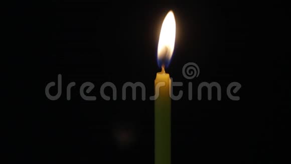 特写照明蜡烛在黑色背景下燃烧蜡烛火焰视频的预览图