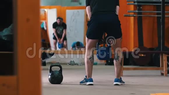 运动训练一个有纹身的腿蹲着的运动员手里有体重视频的预览图
