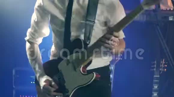 穿着白色衬衫和黑色领带的吉他手在舞台上独奏吉他和舞蹈视频的预览图