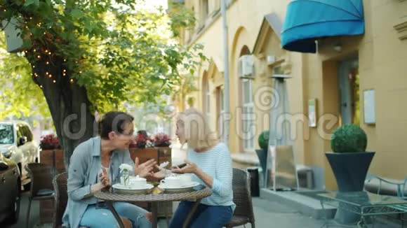 快乐的女士们聊天然后在城市街的户外咖啡馆里做击掌视频的预览图