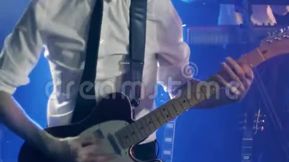 穿着白色衬衫和黑色领带的吉他手在舞台上弹吉他和舞蹈视频的预览图