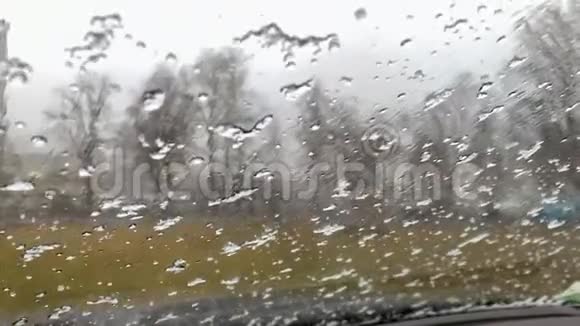 湿冰落在汽车的湿玻璃上雪花流下来视频的预览图