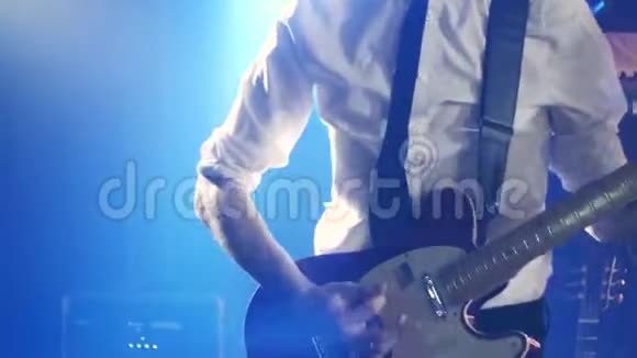 穿着白色衬衫和黑色领带的吉他手在舞台上弹着节奏吉他和舞蹈视频的预览图