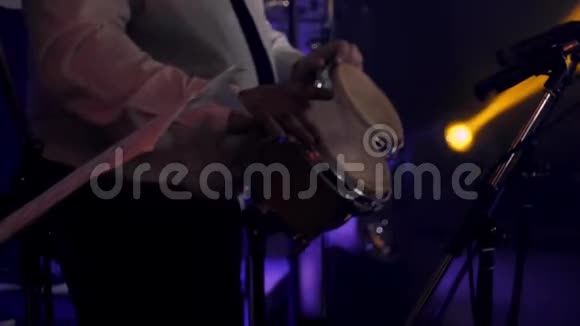 穿白色经典衬衫的邦戈鼓打击乐手和贝斯手在舞台上表演视频的预览图