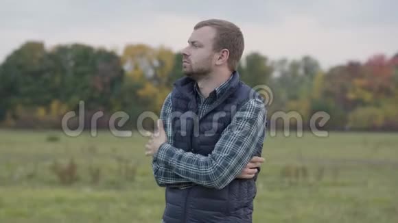 冻僵的白种人站在秋天的草地上扯着背心一个留着白发的留胡子的家伙在等一个人视频的预览图