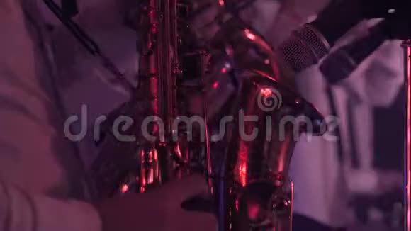 在充满红光的舞台上演奏萨克斯演奏家和邦戈鼓乐演奏家视频的预览图