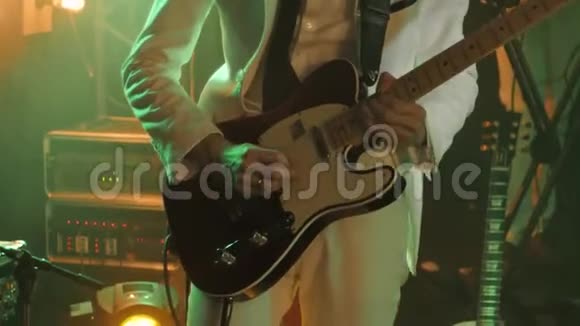 身穿白色时尚套装和黑色领带的吉他手在舞台上弹吉他独奏视频的预览图
