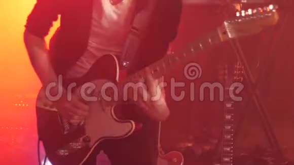 穿黑色衬衫的吉他手在舞台上用手指弹奏电吉他视频的预览图
