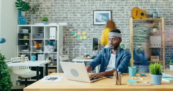美国黑人帅哥在现代办公室使用笔记本电脑的时间间隔视频的预览图