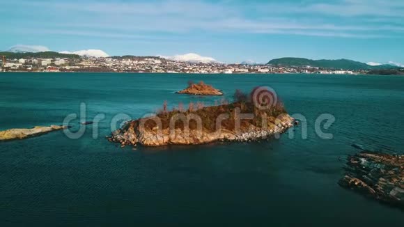 飞越从海中突出的岩石小岛在城市的背景下一阵微风晚冬视频的预览图