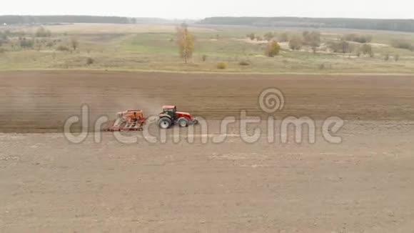 农民在一台能量饱和的拖拉机上播种播种单位在田间播种冬季作物的种子视频的预览图