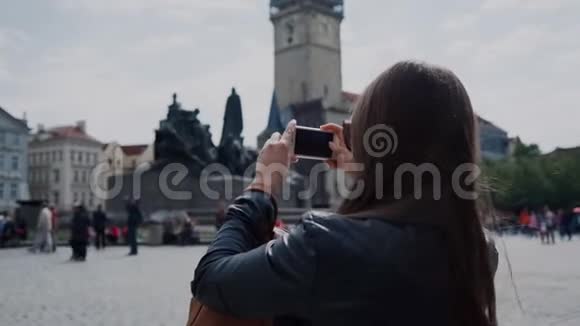 戴墨镜的旅游女孩在捷克布拉格老广场用手机拍照视频的预览图