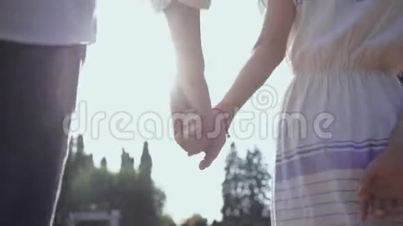 在公园或花园里散步的情侣牵手男人和女人一起在户外玩爱情观念回去视频的预览图