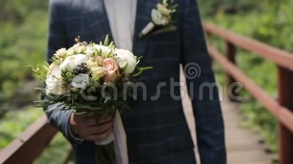 英俊的新郎带着漂亮的婚礼花束视频的预览图
