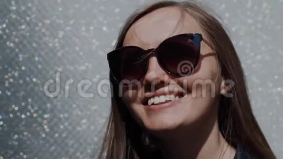 戴墨镜的微笑女孩的画像墙上散落着施华洛世奇的石头视频的预览图