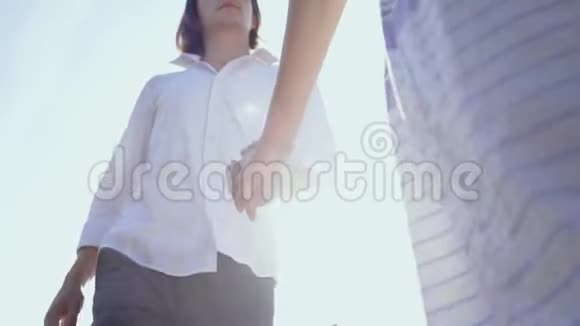 一对年轻的白种人男女手牵手走在户外带着男朋友的女孩跟我来视频的预览图