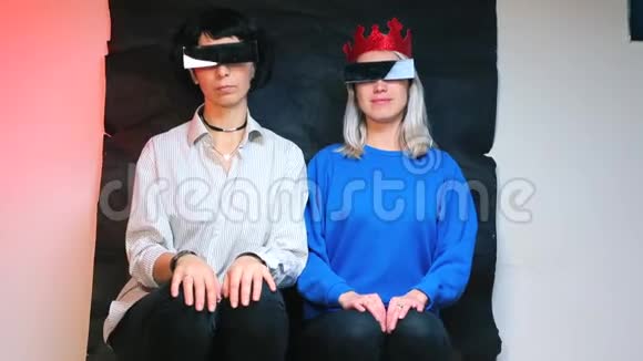 两个戴着黑色眼镜的女孩正坐在椅子上视频的预览图
