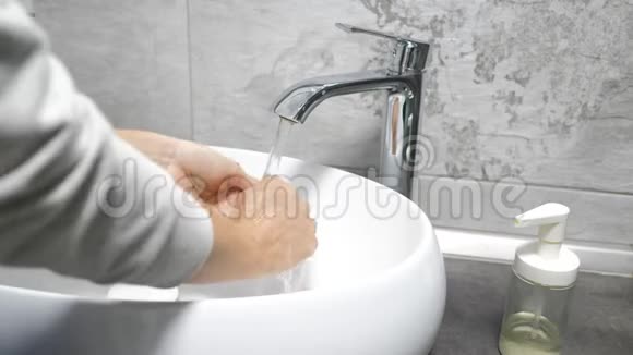 女人在浴室里用水肥皂和泡沫洗手为了避免病毒洗手是很重要的视频的预览图