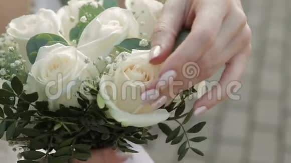 新娘的手触摸婚礼花束特写镜头视频的预览图
