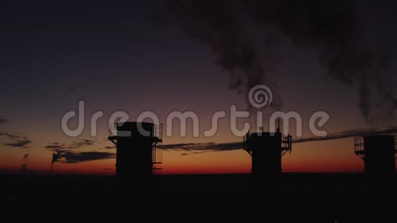 锅炉房在晚城的一片夕阳背景下浓烟来自烟囱高高升起视频的预览图