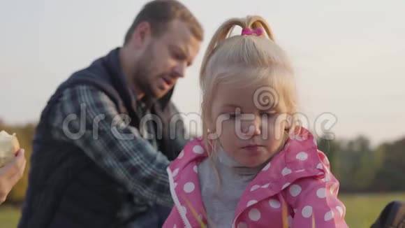 一个金发棕色眼睛的小可爱女孩看着相机的特写肖像可爱的孩子在听视频的预览图