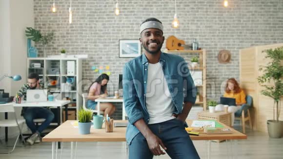 快乐的非裔美国商人在办公室微笑的慢镜头肖像视频的预览图