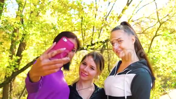 多种族的朋友在秋季花园自拍运动服视频的预览图