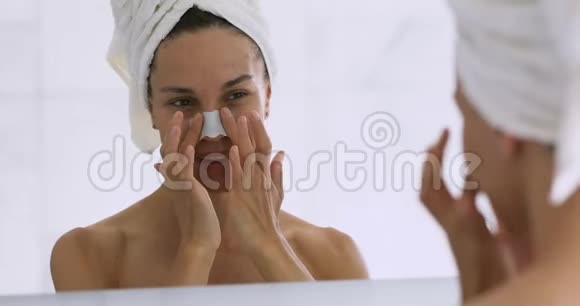 快乐迷人的年轻女性去除鼻条清洁毛孔黑头视频的预览图