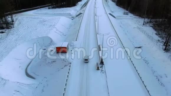 鸟瞰一辆孤独的汽车沿着一条森林雪道驶向黎明家庭用车旅行视频的预览图