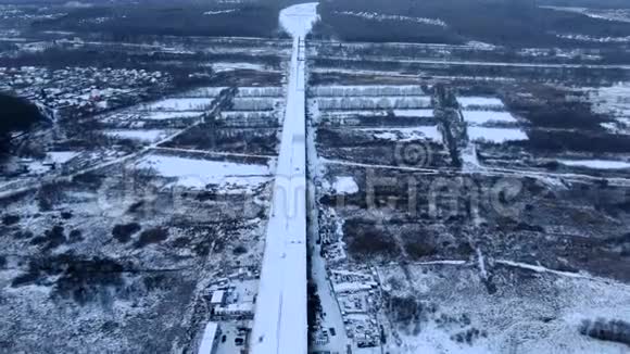 鸟瞰飞行无人机在雪地高速公路和桥梁上的河流高空视频的预览图