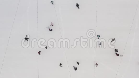 市中心新鲜空气中人们在冰场的冰面上滑动的俯视图体育活动的理念视频的预览图