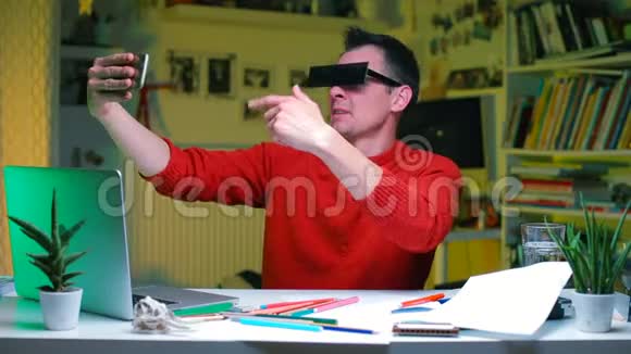 办公室桌上一个滑稽的尤图伯正在用智能手机拍摄自己的视频视频的预览图
