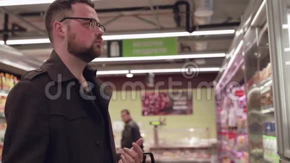 男买家在超市里选择和嗅冷冻鱼视频的预览图