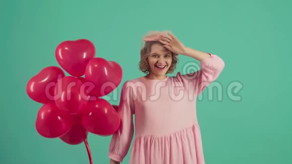 情人节美女带着红色气球笑绿色背景美丽幸福的年轻女子假日聚会视频的预览图