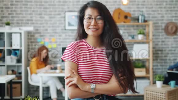 亚洲女商人站在办公室双臂交叉微笑视频的预览图