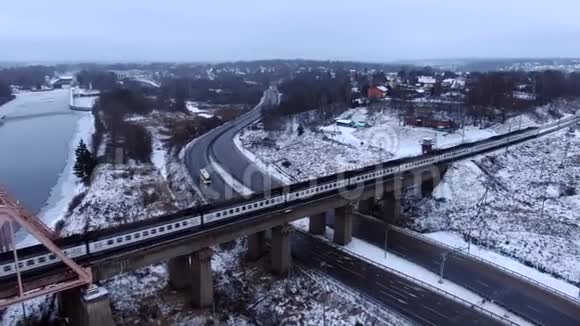 从火车后面的无人机在结冰的河流上的一座桥上追踪空中视野视频的预览图