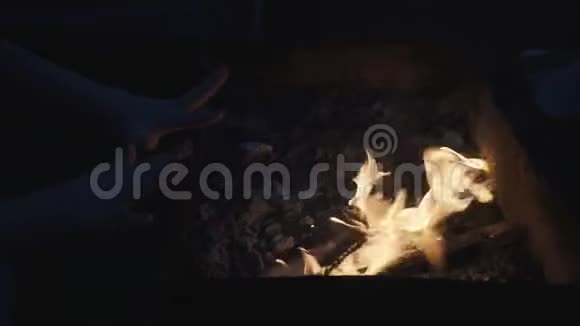 小孩在炉火旁温暖双手视频的预览图