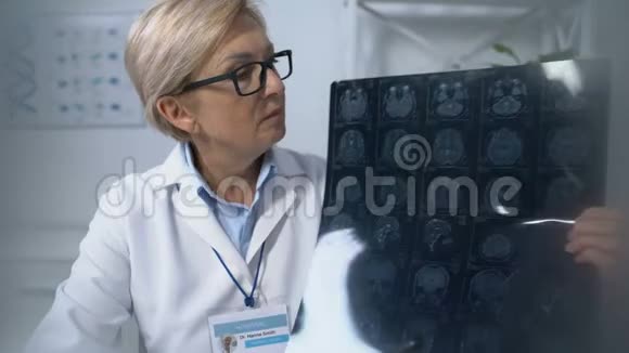 患者观察成熟女性医师持脑X线体检视频的预览图