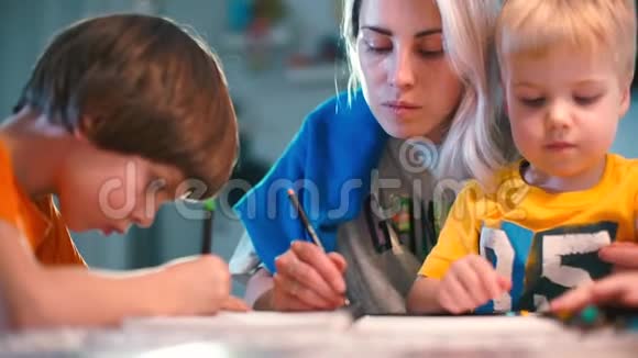 妈妈和两个儿子坐在一张桌子上画一幅画视频的预览图