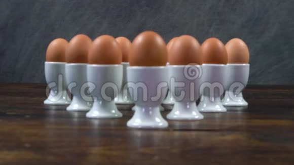 木桌上放着一组放在蛋杯里的煮鸡蛋视频的预览图