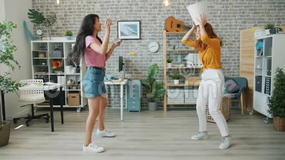 快乐的年轻女性上班族在工作中玩得开心把纸扔进垃圾箱视频的预览图