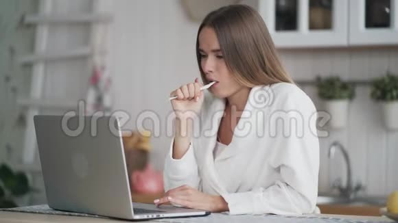 女孩用牙刷刷牙早上用笔记本电脑查看邮件视频的预览图