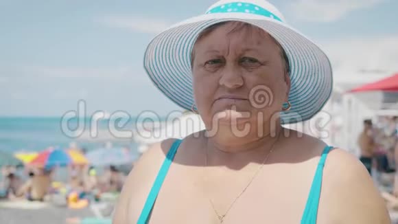 海滩上的中年妇女年龄休闲和人的概念把戴着太阳帽的快乐高级女人关起来视频的预览图