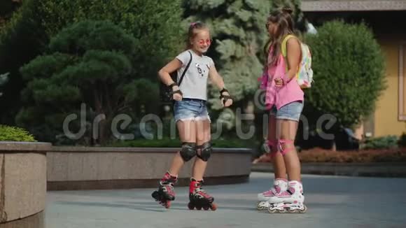 两个女孩在城市公园溜冰的滑稽舞蹈视频的预览图