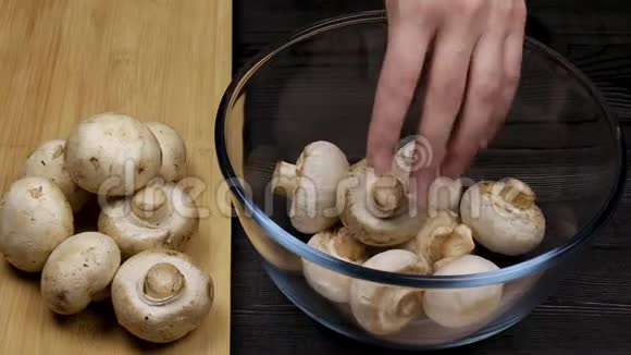厨师长把他剥去的香瓜放在一个玻璃碗里旁边是一堆蘑菇在一个切割板上视频的预览图