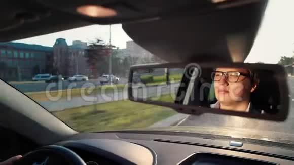 戴眼镜的成年男子正驾驶汽车后视镜视频的预览图
