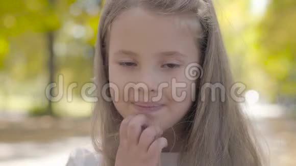 年轻漂亮的棕色眼睛女孩有着长长的黑发对着镜头微笑可爱的高加索儿童的特写视频的预览图