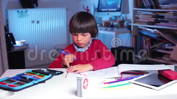 孩子坐在桌子旁画一个孩子画视频的预览图