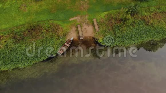 停泊在河沙滩上的木制渔船的俯视图视频的预览图