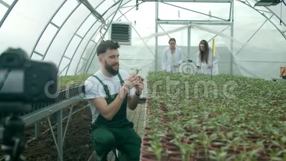 年轻农民在温室里录制视频视频的预览图
